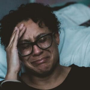 A man with glasses is laying down